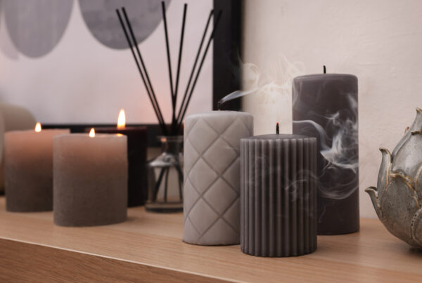 Blown out candles and smoke on wooden shelf indoors