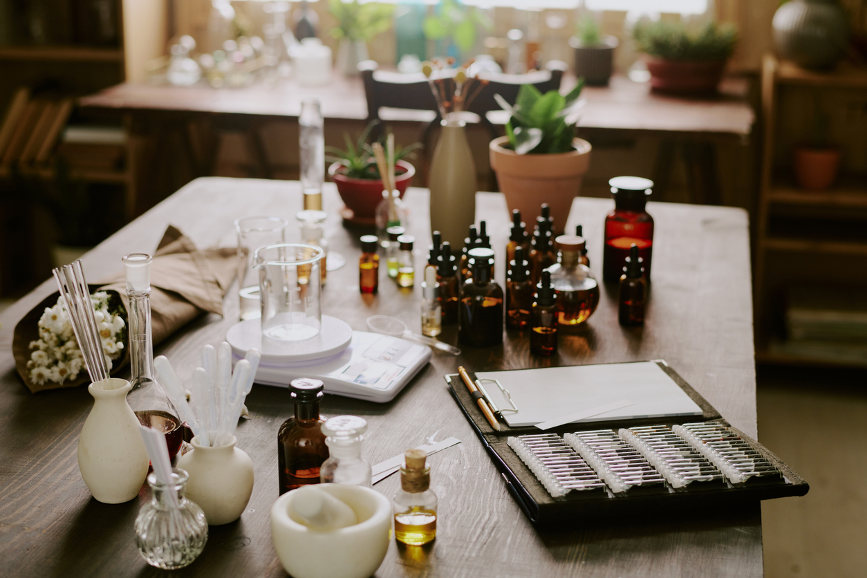 Small brown glass bottles full of essential oil and glass and plastic pipette on wooden table