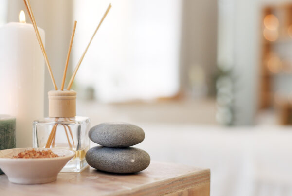 Spa, rock and candle to relax in a room with atmosphere, mood or ambience in a health club. Wellness, luxury and treatment with still life objects on a table in a clinic for rest and relaxation